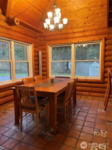 a dining room with a wooden table and chairs