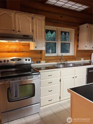 a kitchen with granite countertop a stove sink and cabinets