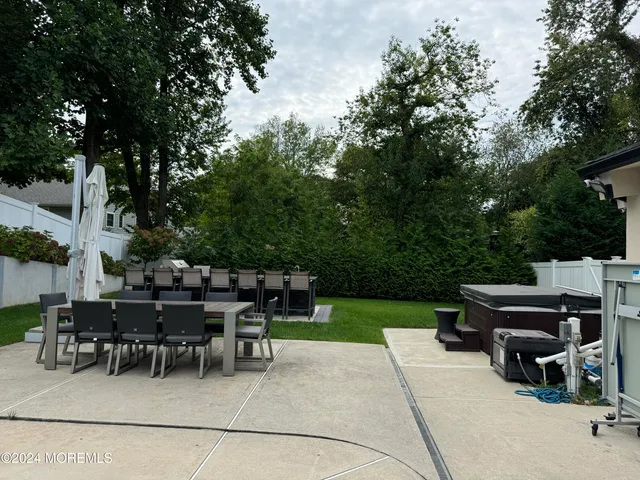 a view of a patio with a dining table and chairs with a fire pit