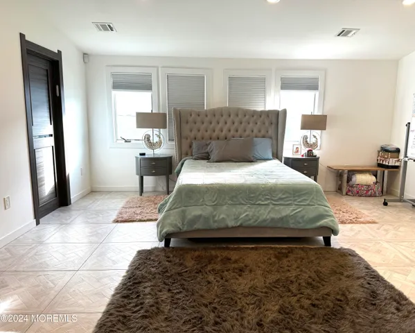 a bedroom with a large bed and a dresser