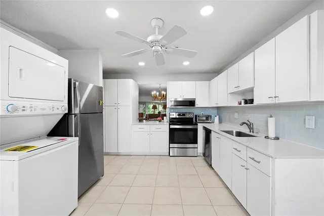 a kitchen with stainless steel appliances granite countertop a refrigerator sink and white cabinets