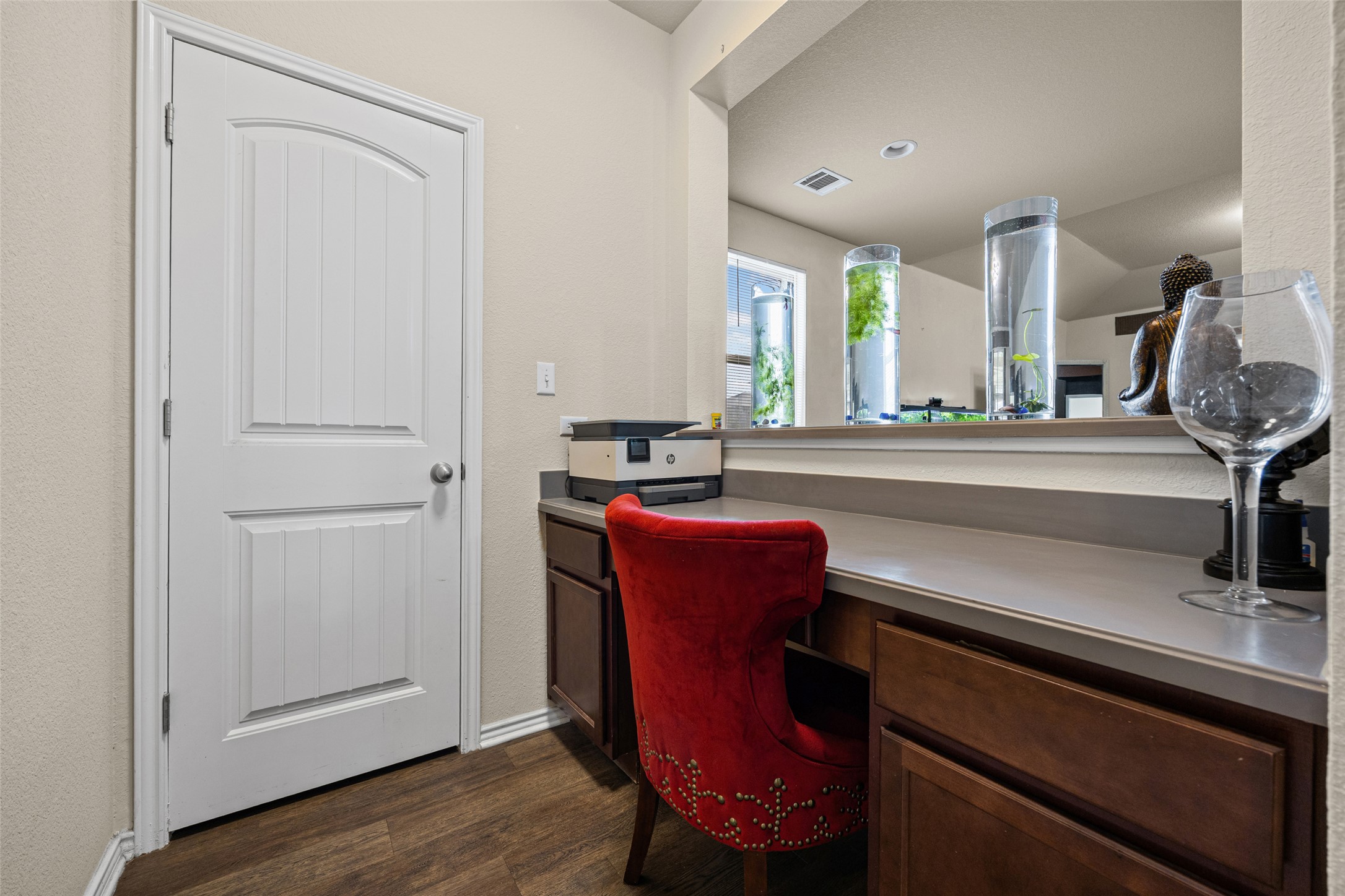 19113 Rookery Trail Pflugerville, TX 78660 - Photo 6 of 36 Built-in desk area featuring wood-finish flooring, a light-toned countertop, and dark wood cabinetry