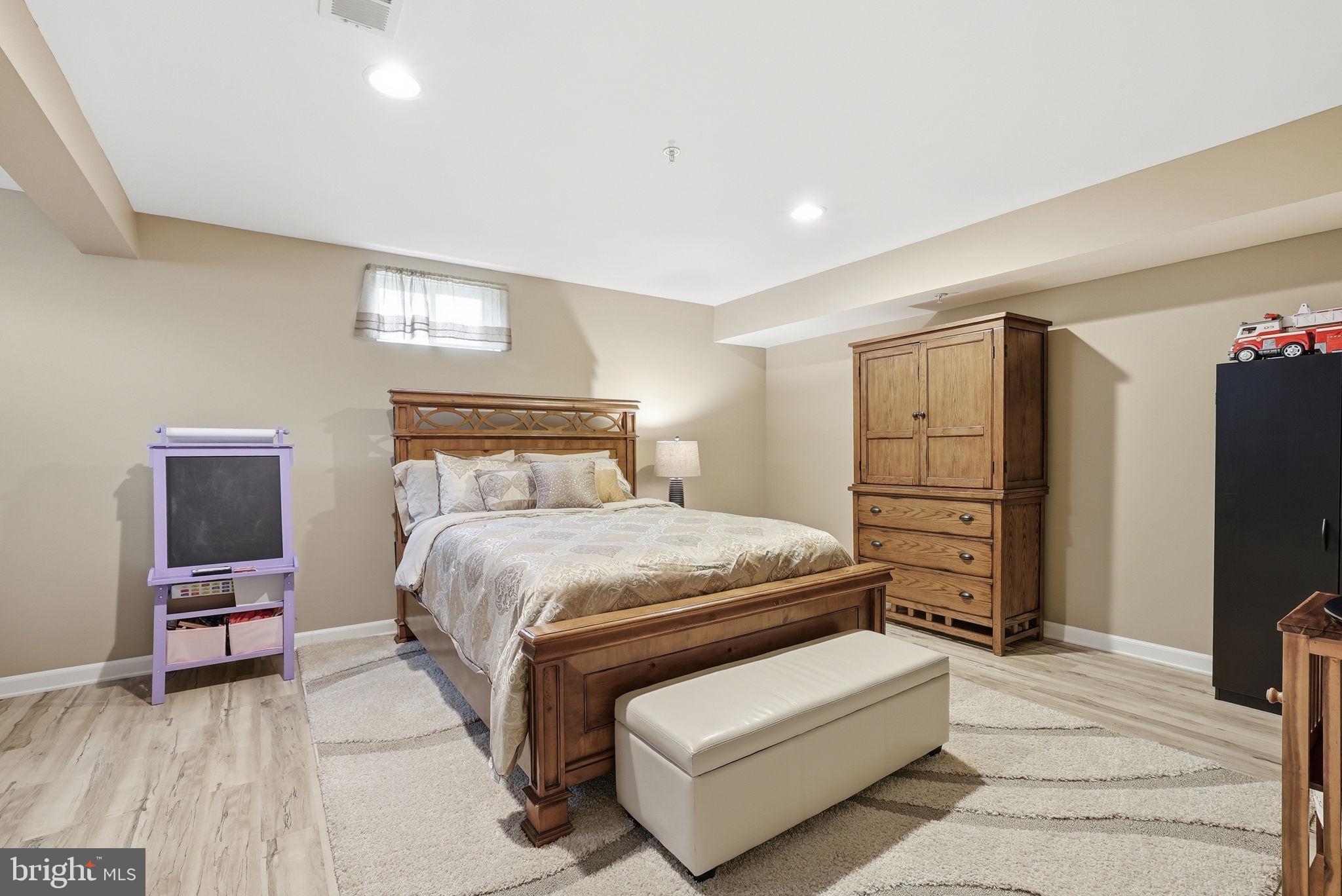 6900 Lenape Court Brandywine, MD 20613 - Photo 35 of 43 a bedroom with a bed and a flat tv screen on dresser