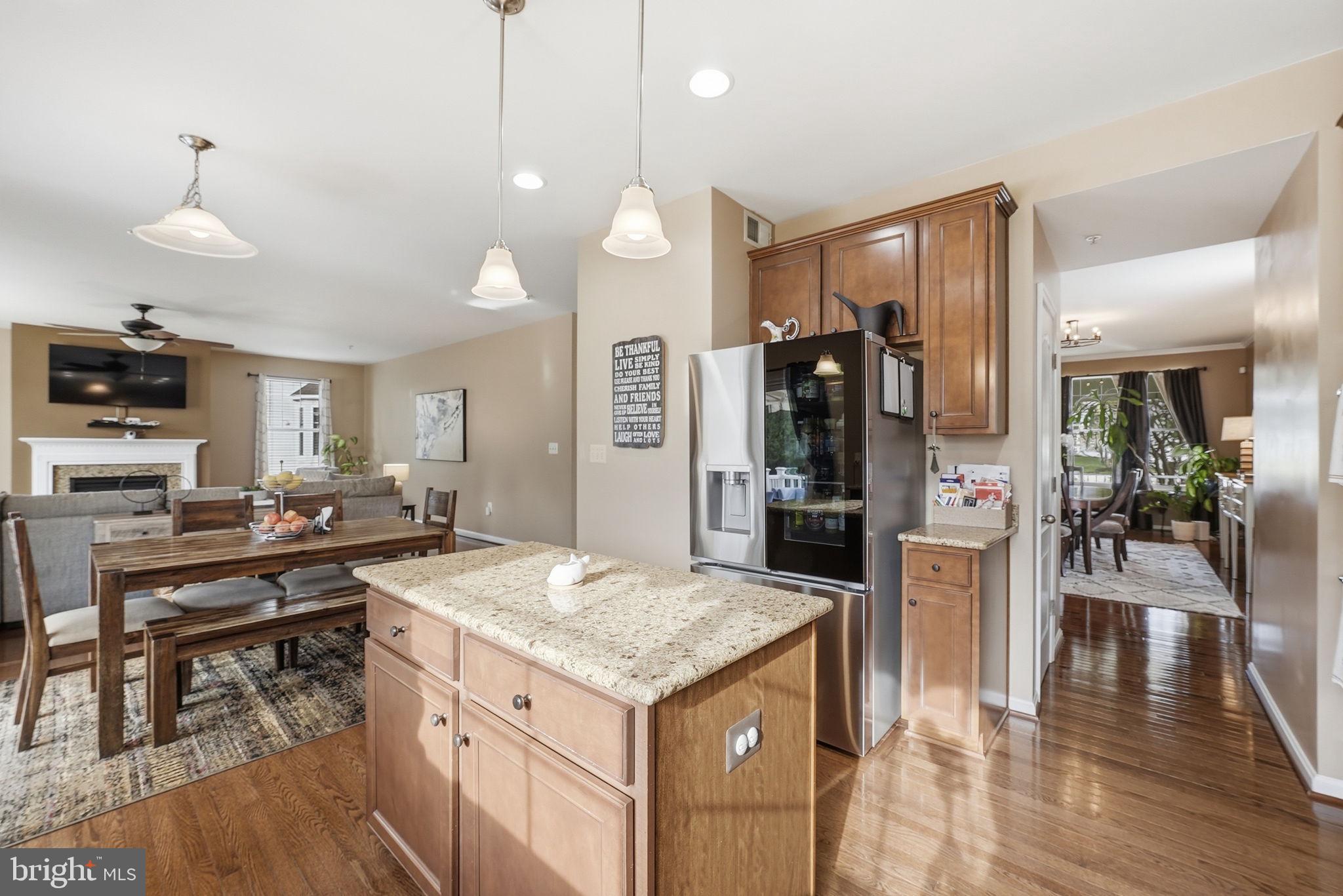 6900 Lenape Court Brandywine, MD 20613 - Photo 5 of 43 a kitchen with a stove a refrigerator and a dining table with wooden floor