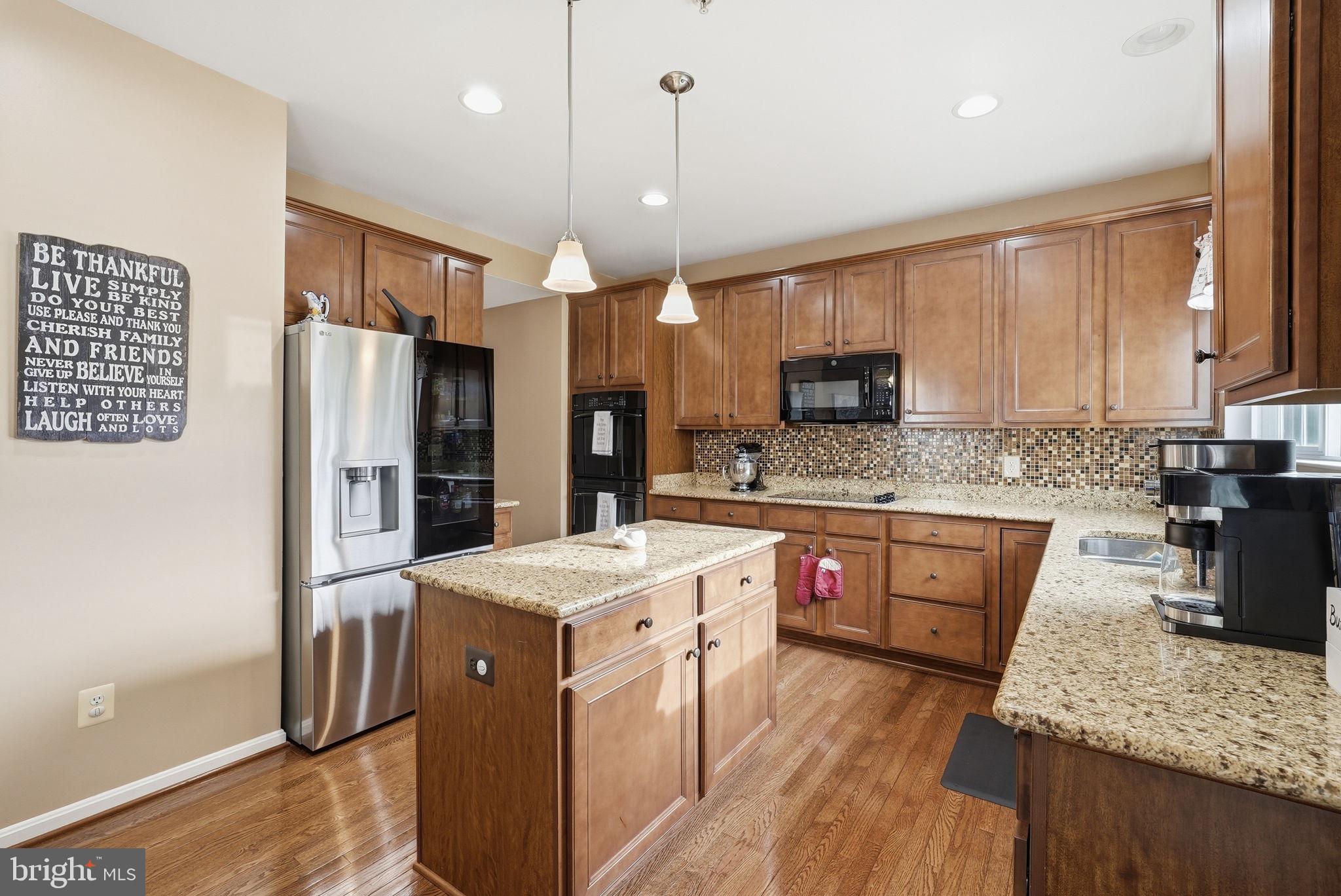 6900 Lenape Court Brandywine, MD 20613 - Photo 7 of 43 a kitchen with stainless steel appliances granite countertop a refrigerator a stove a sink dishwasher and a oven with wooden floor
