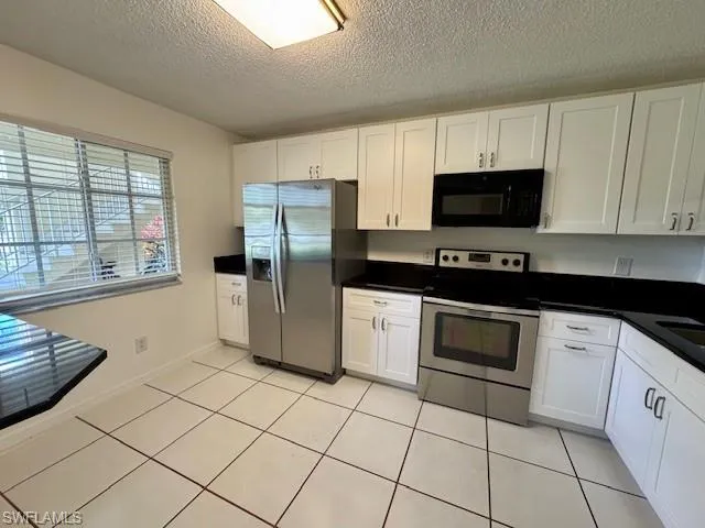 a kitchen with stainless steel appliances a refrigerator sink and microwave