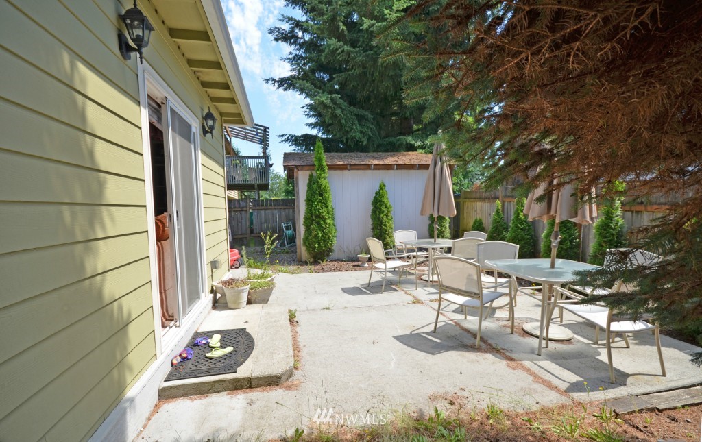 2608 165th Place Southeast Bothell, WA 98012 - Photo 13 of 13 a view of a patio with table and chairs and floor to ceiling window