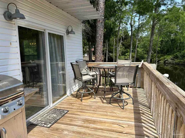 a view of a patio with table and chairs with wooden floor and fence