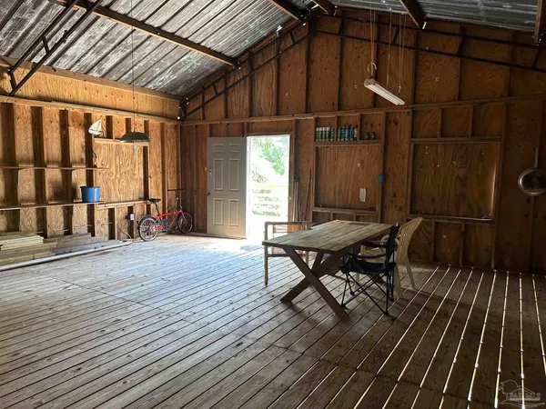 a view of a patio with table and chairs with wooden floor and fence