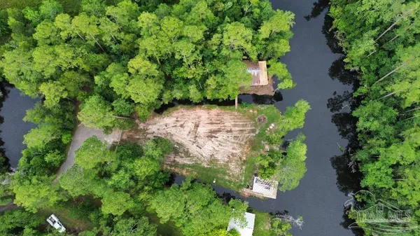 an aerial view of residential house with outdoor space and trees all around