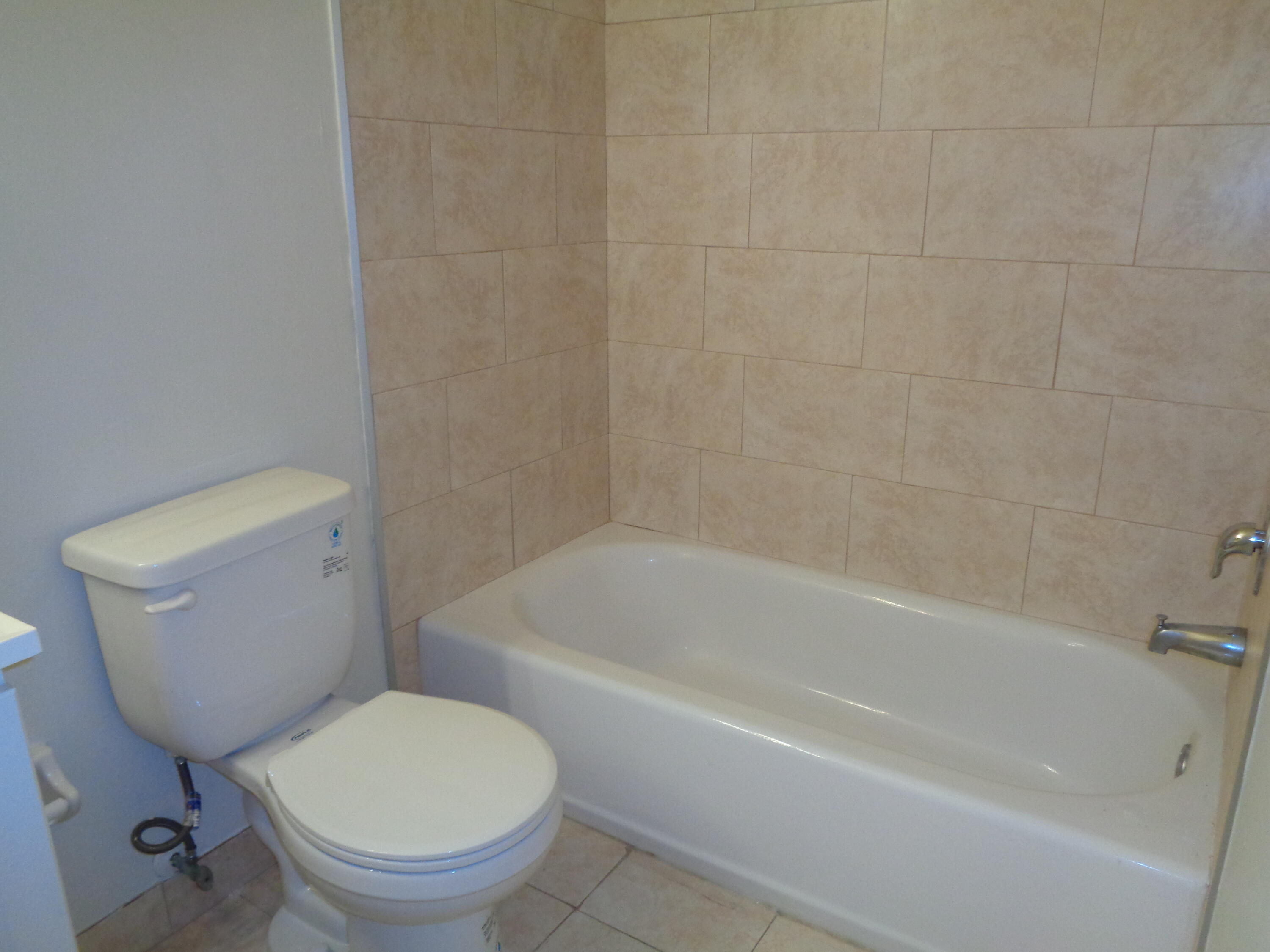 301 Olivewood Place, Unit O227 Boca Raton, FL 33431 - Photo 16 of 20 a white toilet and tub sitting next to a bathroom sink