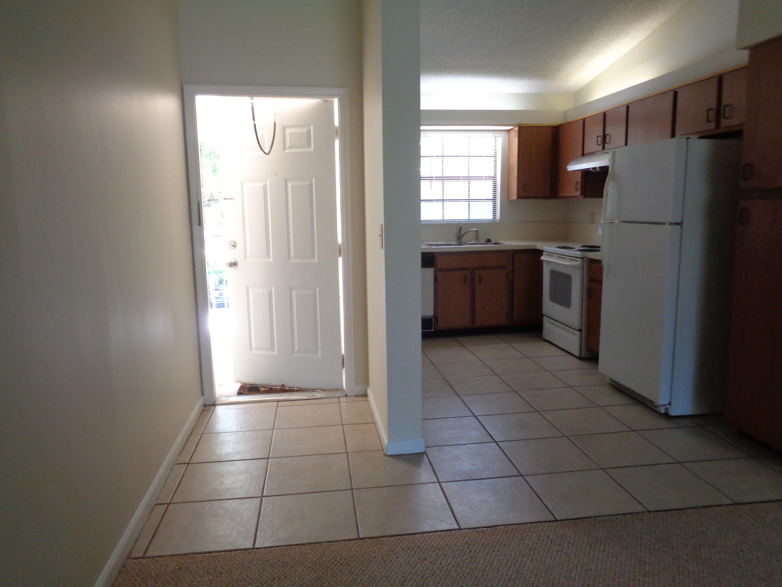 301 Olivewood Place, Unit O227 Boca Raton, FL 33431 - Photo 5 of 20 a kitchen with granite countertop a refrigerator and a stove