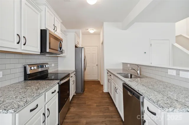 a kitchen with granite countertop a sink and cabinets