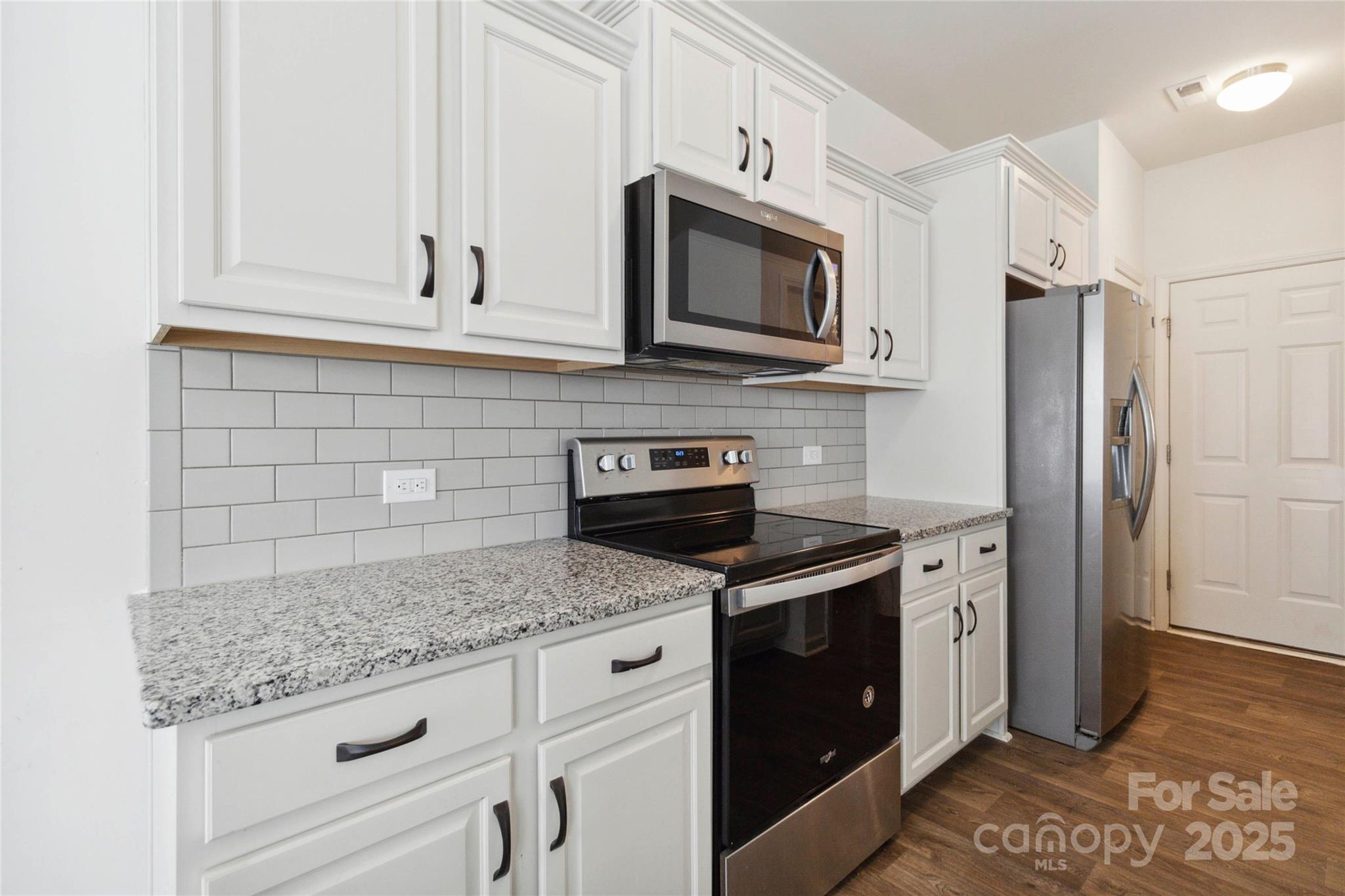 14027 Clayborn Street Midland, NC 28107 - Photo 13 of 35 a kitchen with granite countertop white cabinets stainless steel appliances and a counter space
