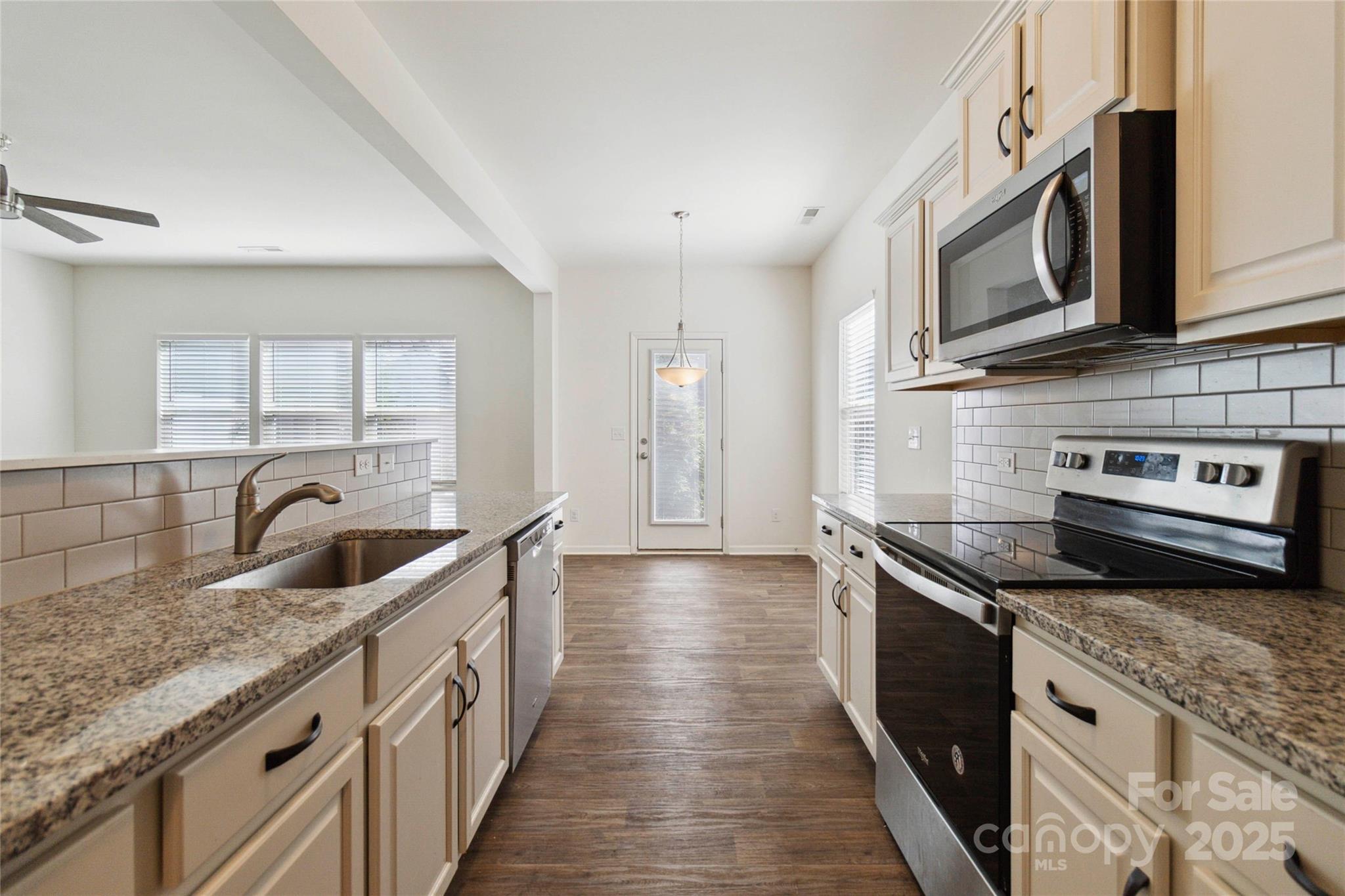 14027 Clayborn Street Midland, NC 28107 - Photo 14 of 35 a kitchen with stainless steel appliances granite countertop a sink a stove and a wooden cabinets