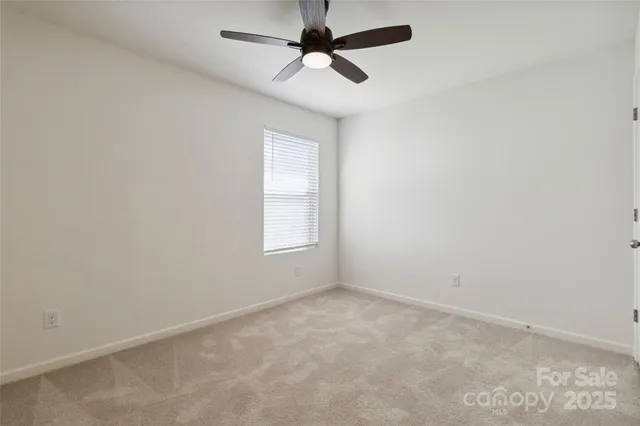 an empty room with a ceiling fan and a window