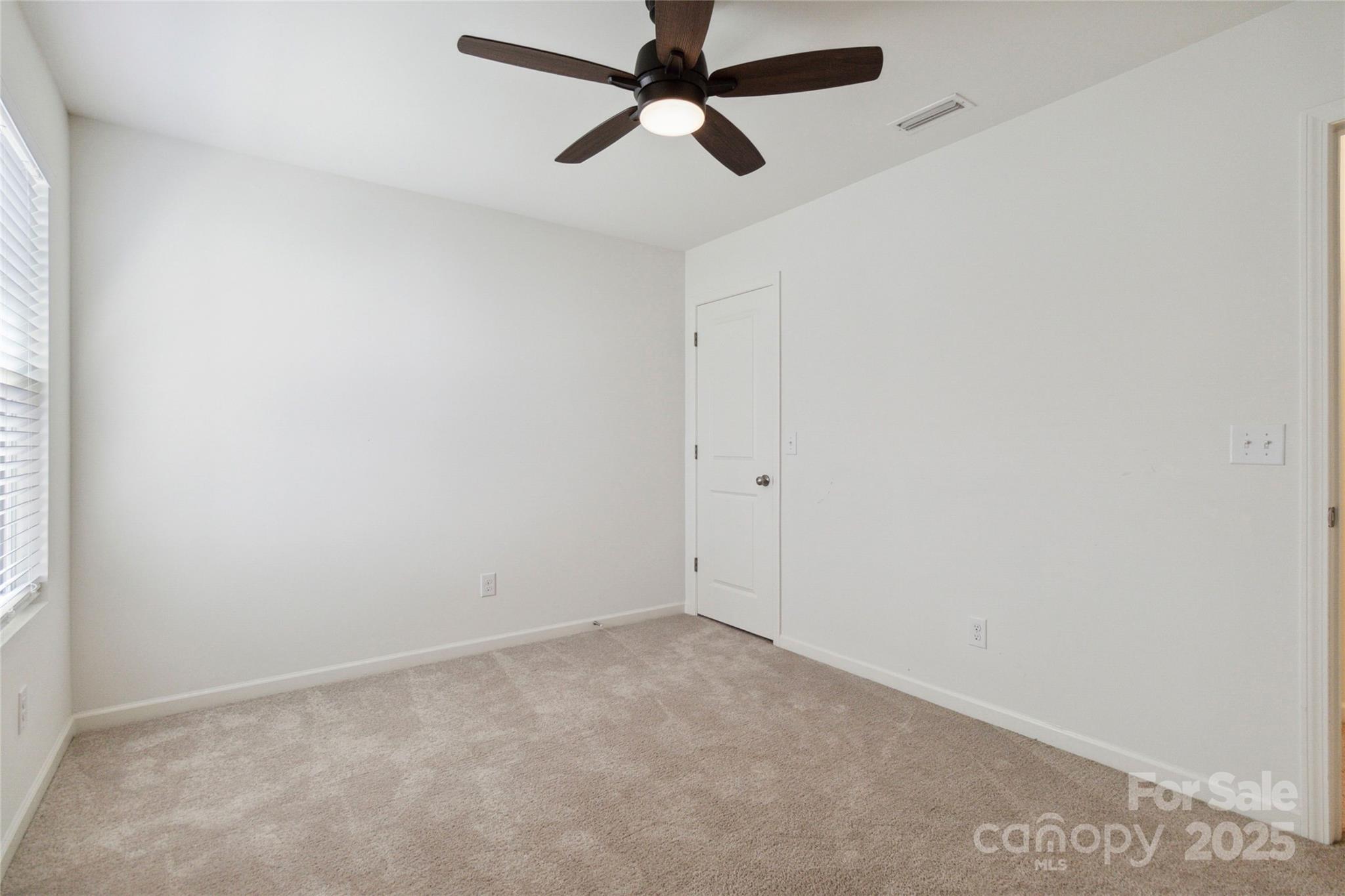 14027 Clayborn Street Midland, NC 28107 - Photo 27 of 35 an empty room with a ceiling fan and a window