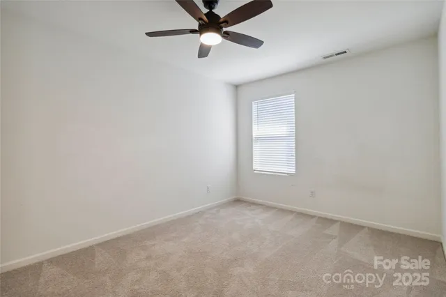 an empty room with a ceiling fan