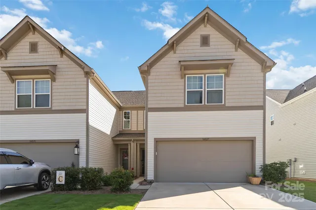 a view of a white house next to a yard