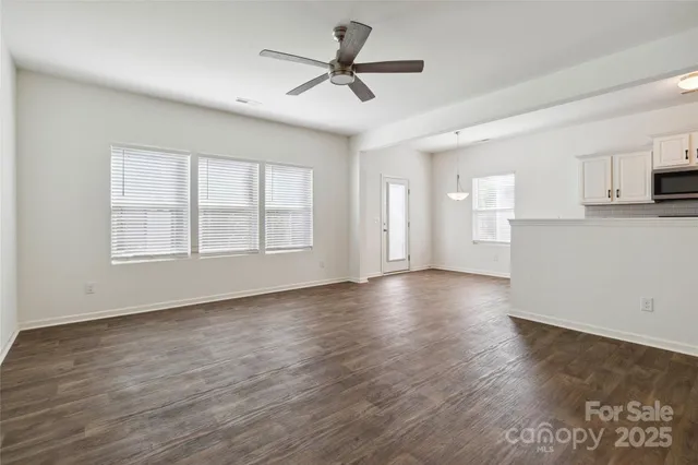 a view of a kitchen with wooden floor and a ceiling fan