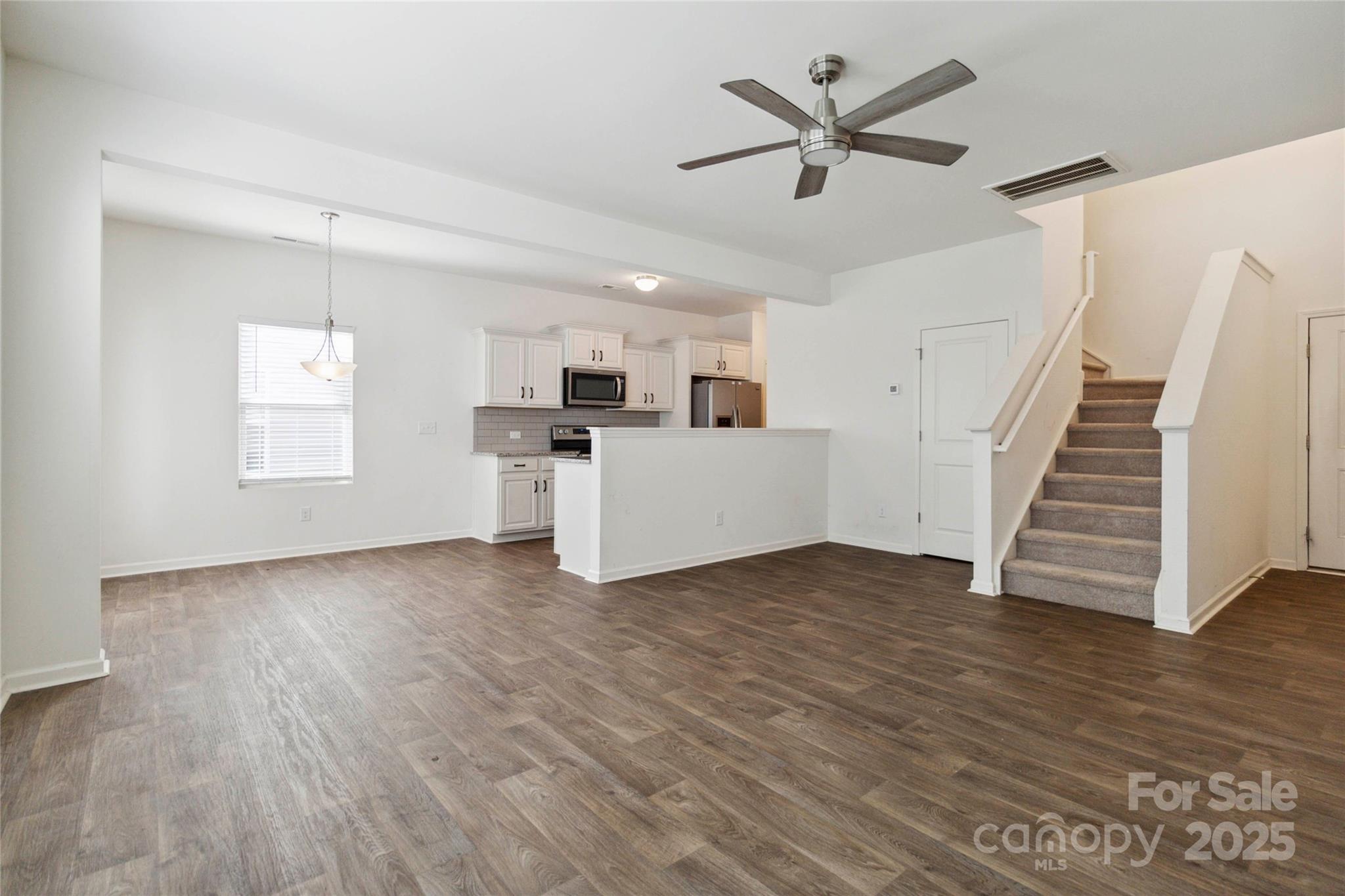 14027 Clayborn Street Midland, NC 28107 - Photo 8 of 35 a view of a kitchen with wooden floor and a ceiling fan
