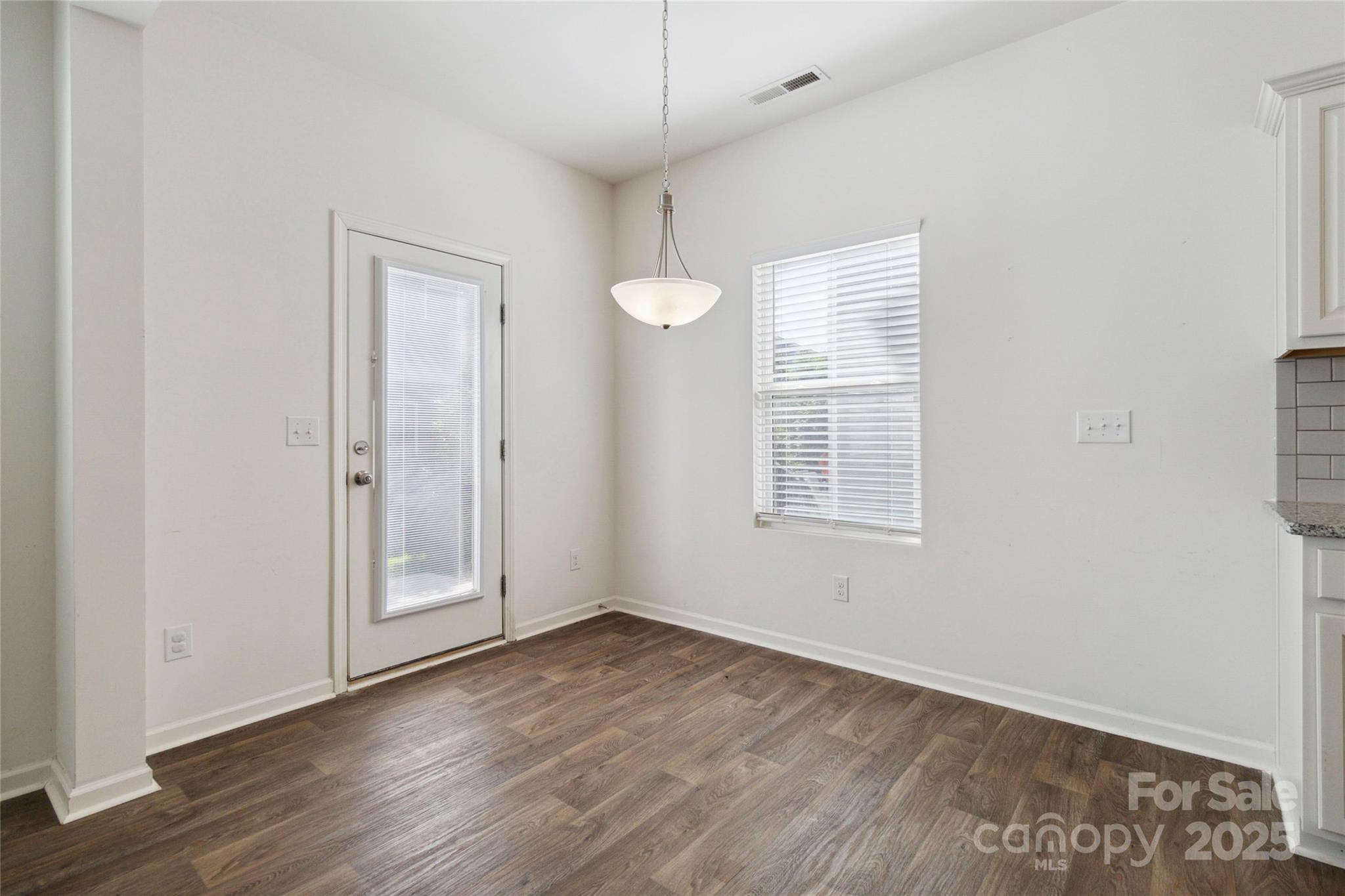14027 Clayborn Street Midland, NC 28107 - Photo 9 of 35 an empty room with wooden floor and windows