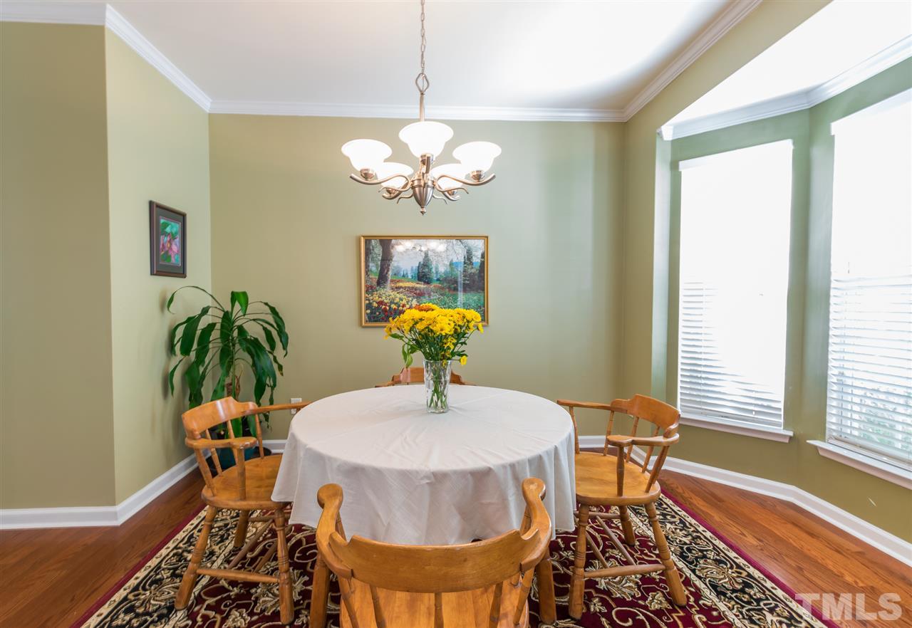 8412 Aztec Dawn Court Raleigh, NC 27613 - Photo 3 of 24 a dining room with furniture a chandelier and wooden floor