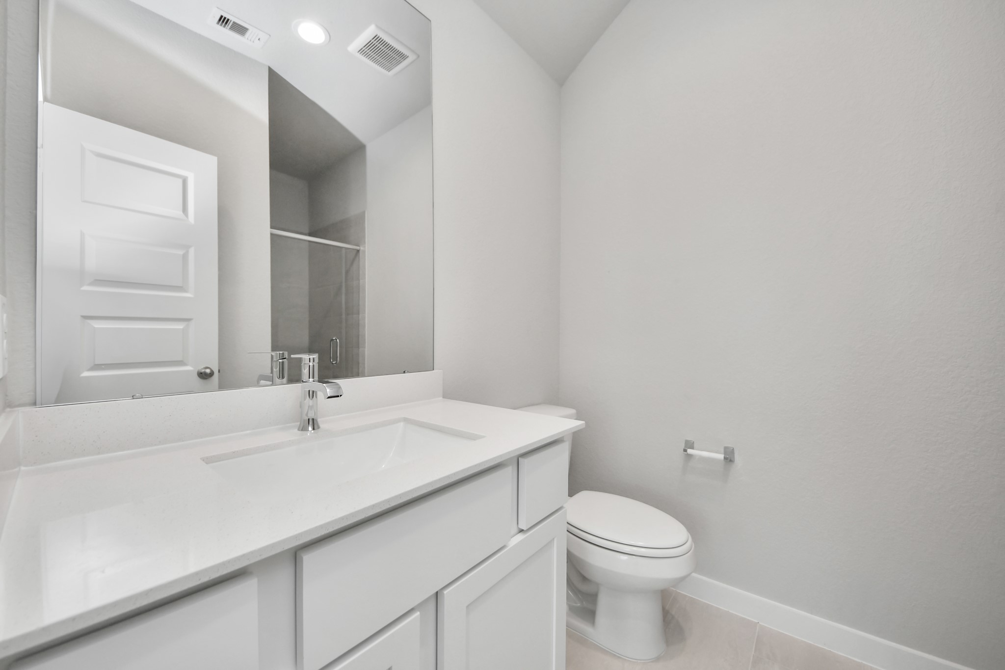 311 Ice Shr Trail Dayton, TX 77535 - Photo 5 of 35 Secondary bath features tile flooring, a walk-in shower with tile surround, light stained wood cabinets, beautiful light countertop. Sample photo of completed home with similar floor plan. Actual colors and selections may vary.