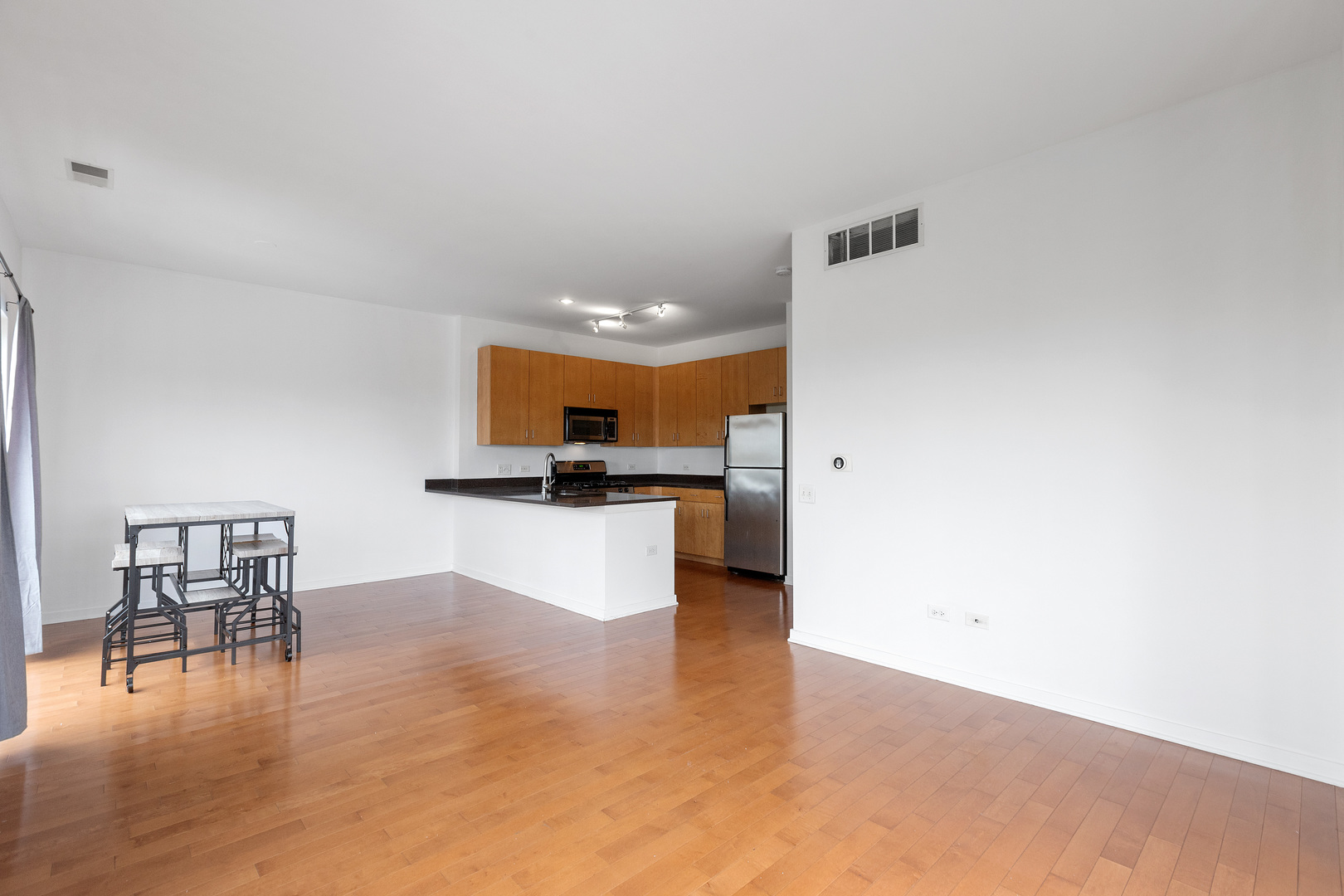 1155 West Roosevelt Road, Unit 402 Chicago, IL 60608 - Photo 8 of 24 a view of kitchen with furniture and wooden floor