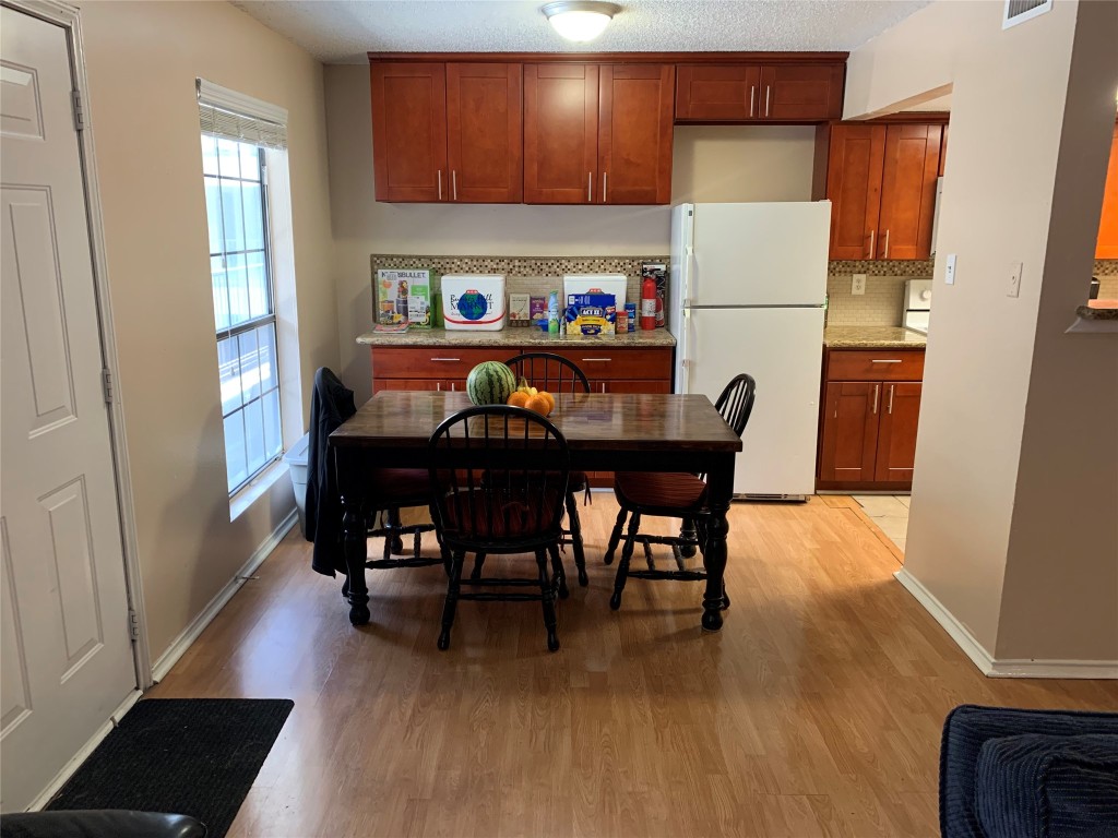 2401 Leon Street, Unit 203 Austin, TX 78705 - Photo 13 of 22 a dining table chairs and a refrigerator in a kitchen