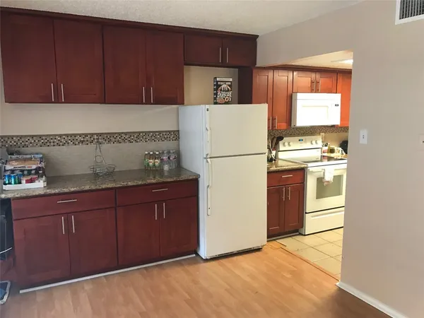 a kitchen with a refrigerator sink stove and cabinets