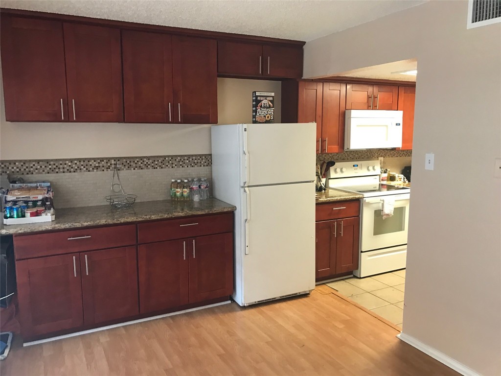 2401 Leon Street, Unit 203 Austin, TX 78705 - Photo 2 of 22 a kitchen with a refrigerator sink stove and cabinets
