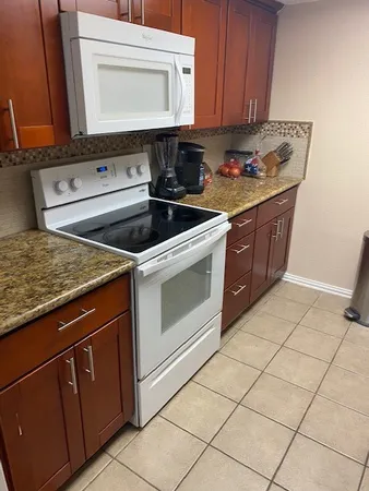a kitchen with stainless steel appliances granite countertop a stove a sink and a microwave