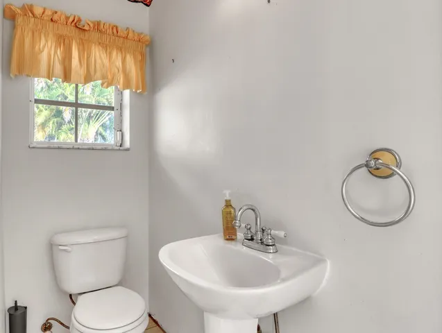a bathroom with a toilet sink and mirror