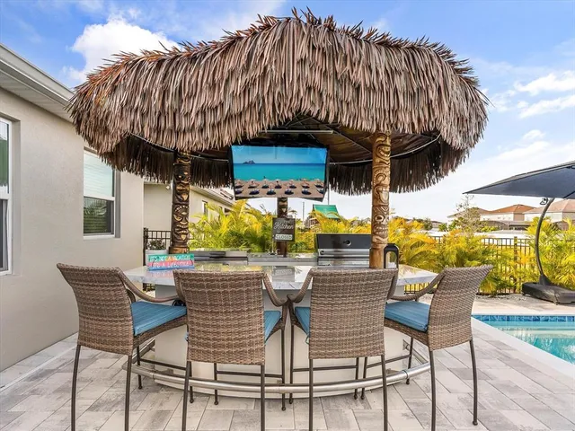 a view of a swimming pool with a lounge chair and palm trees