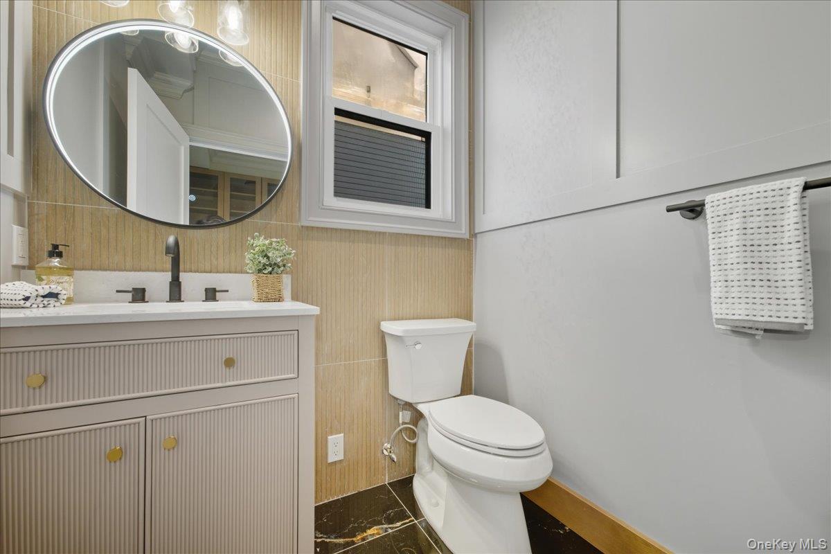 3 Bentley Road Plainview, NY 11803 - Photo 20 of 41 a bathroom with a toilet a sink and mirror
