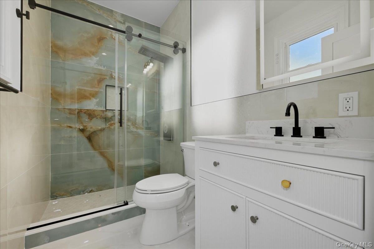 3 Bentley Road Plainview, NY 11803 - Photo 24 of 41 a bathroom with a shower a sink a toilet and a mirror