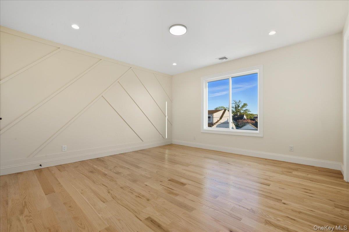 3 Bentley Road Plainview, NY 11803 - Photo 32 of 41 an empty room with wooden floor and window