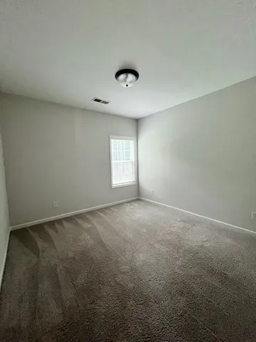 an empty room with windows and ceiling fan view