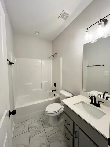 a bathroom with a double vanity sink toilet mirror and shower