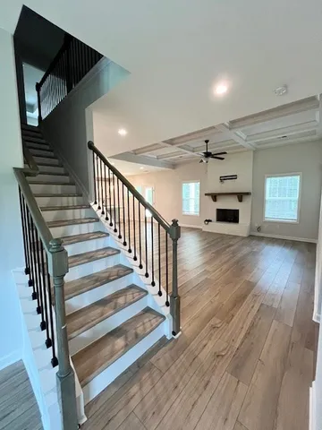 a view of a hallway with wooden floor and stairs