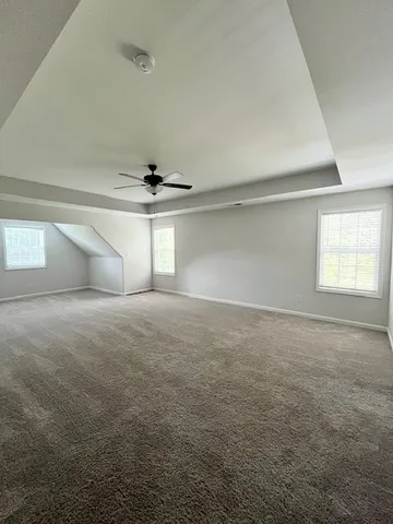 en empty room with windows and fan