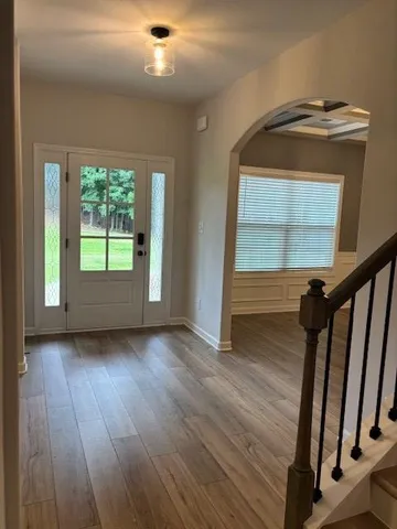 a view of a hallway with wooden floors and stairs