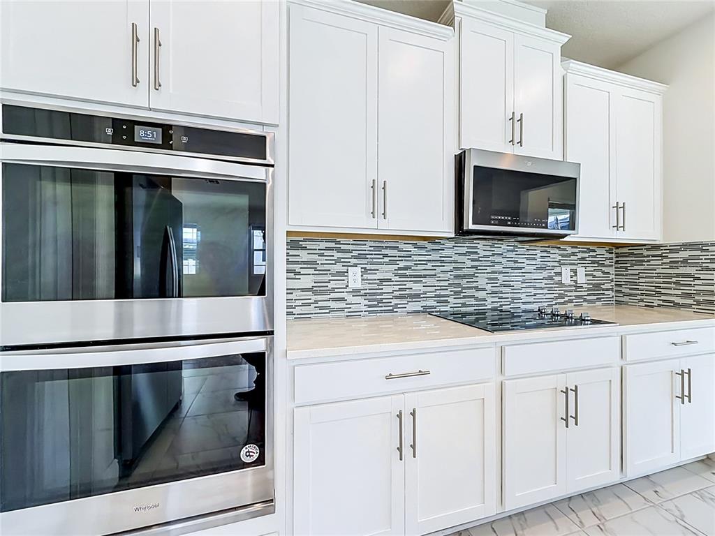 16822 Wingspread Loop Winter Garden, FL 34787 - Photo 17 of 47 a kitchen with granite countertop white cabinets stainless steel appliances and sink