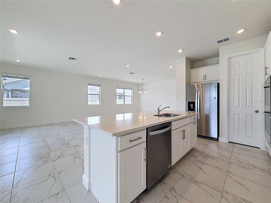 16822 Wingspread Loop Winter Garden, FL 34787 - Photo 18 of 47 a kitchen with stainless steel appliances granite countertop a sink and a refrigerator