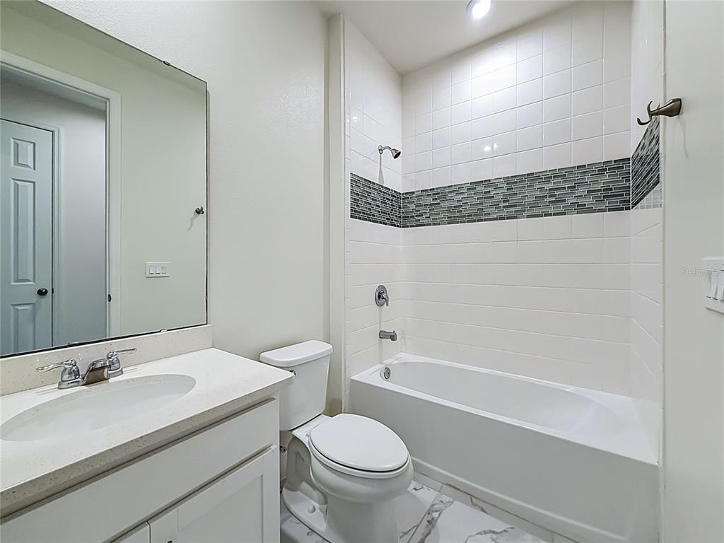 16822 Wingspread Loop Winter Garden, FL 34787 - Photo 29 of 47 a bathroom with a granite countertop sink a toilet and a bathtub