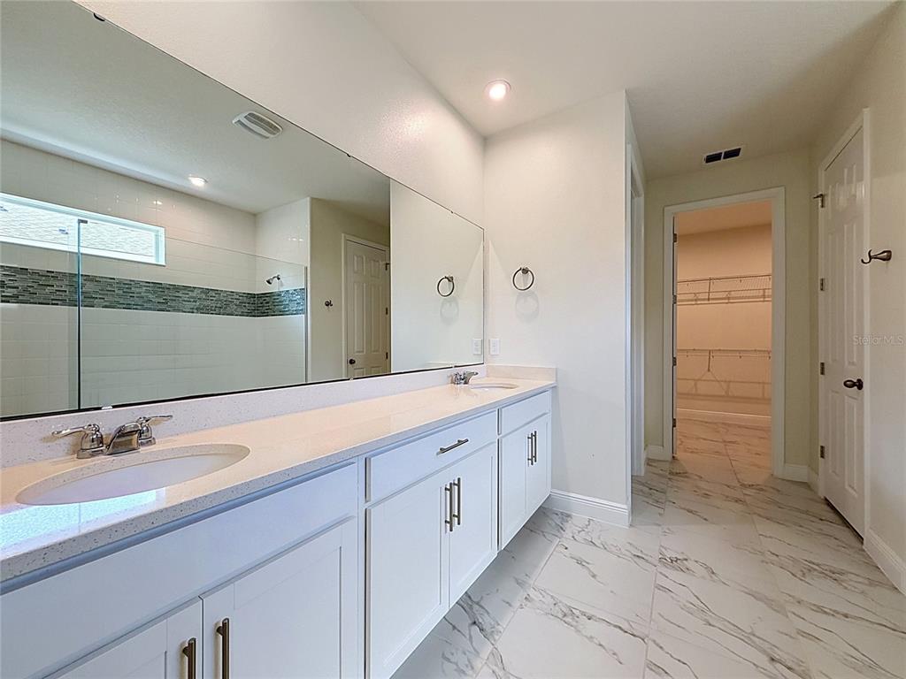 16822 Wingspread Loop Winter Garden, FL 34787 - Photo 33 of 47 a spacious bathroom with a granite countertop sink a mirror and a