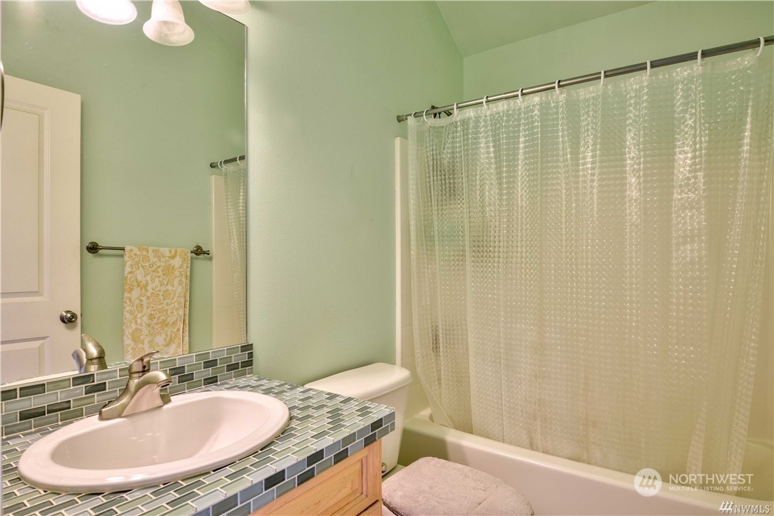3315 Rockefeller Avenue, Unit 4 Everett, WA 98201 - Photo 25 of 29 a bathroom with a granite countertop sink toilet and a mirror