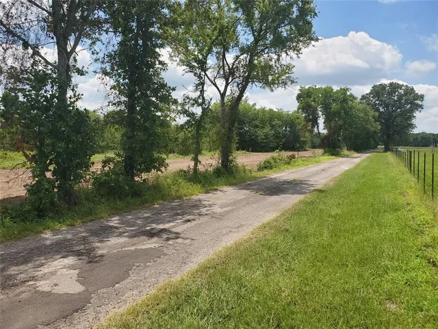 a view of a field with trees in background