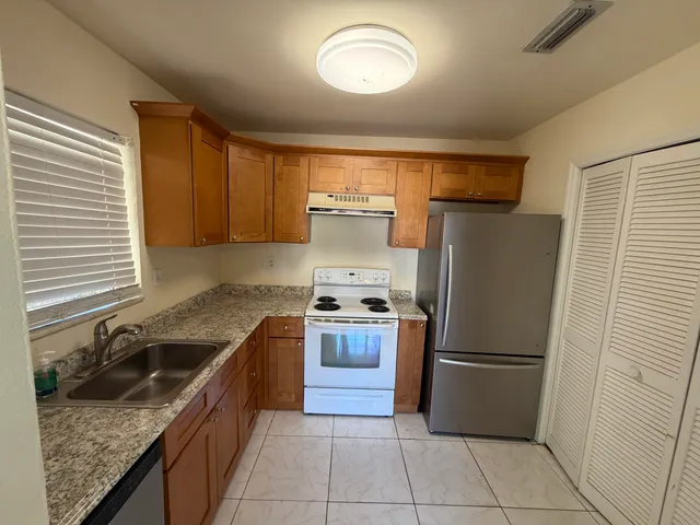 a kitchen with stainless steel appliances granite countertop a refrigerator stove and sink